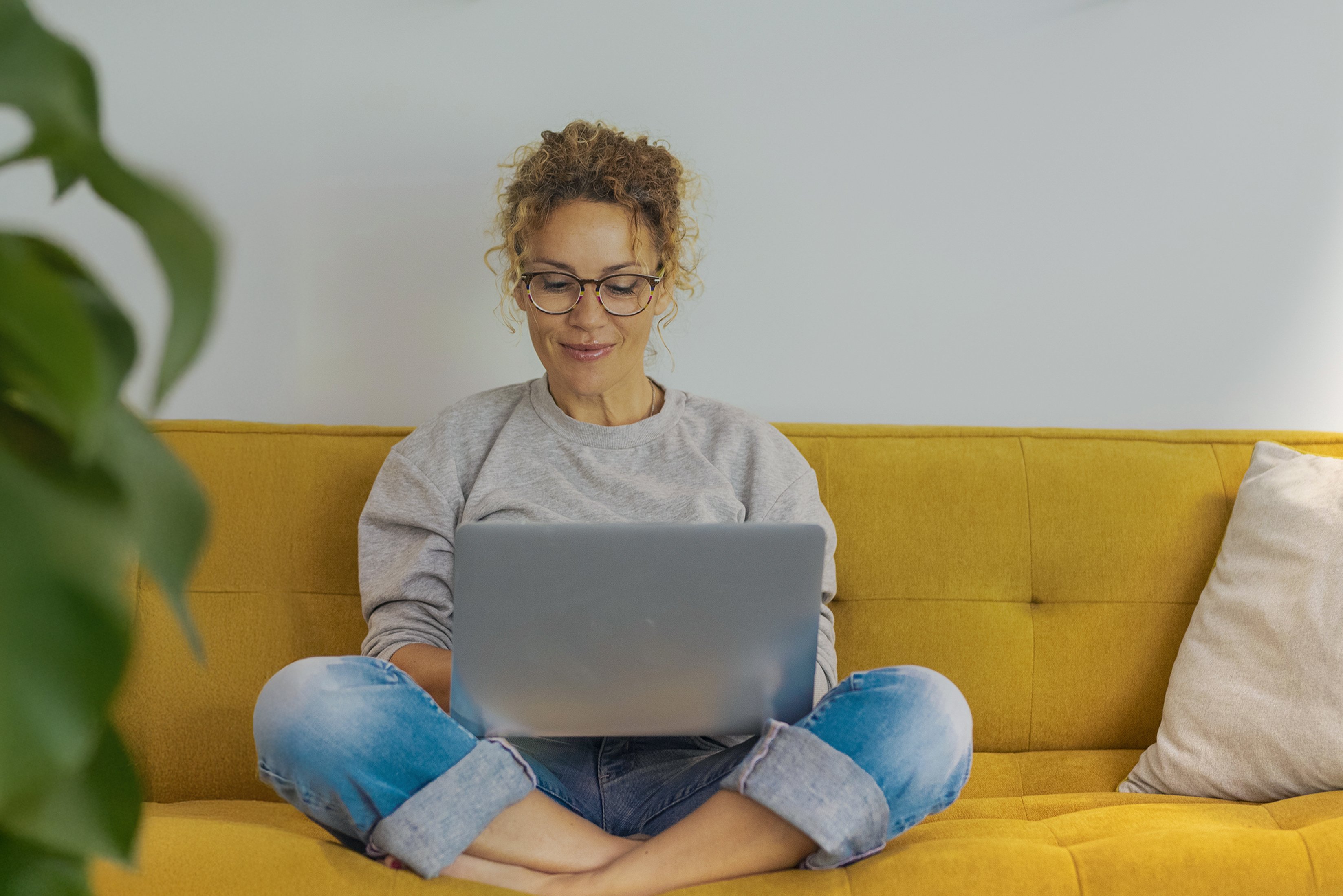 Woman sitting on couch with laptop