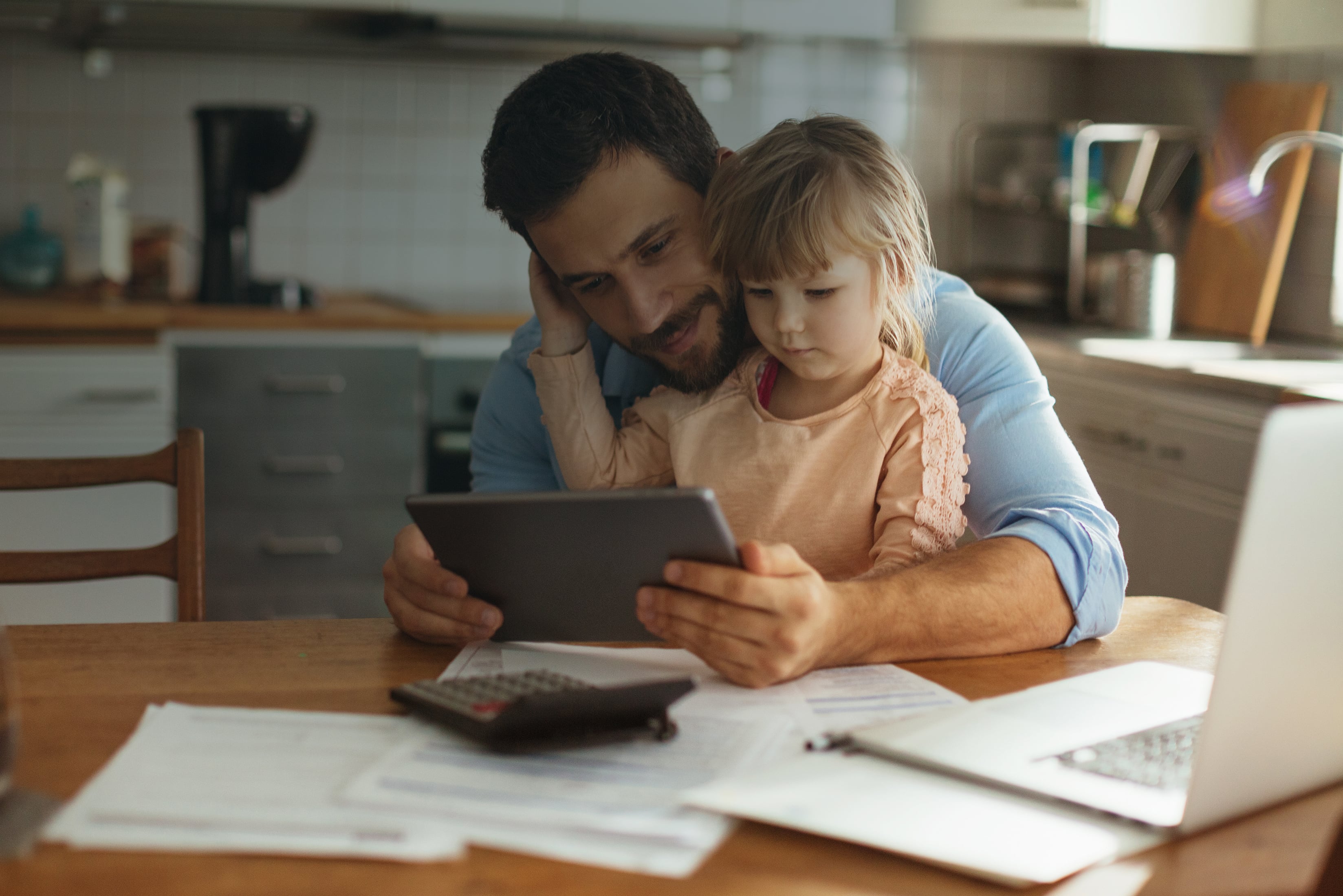 Father and daughter sitting in kitchen