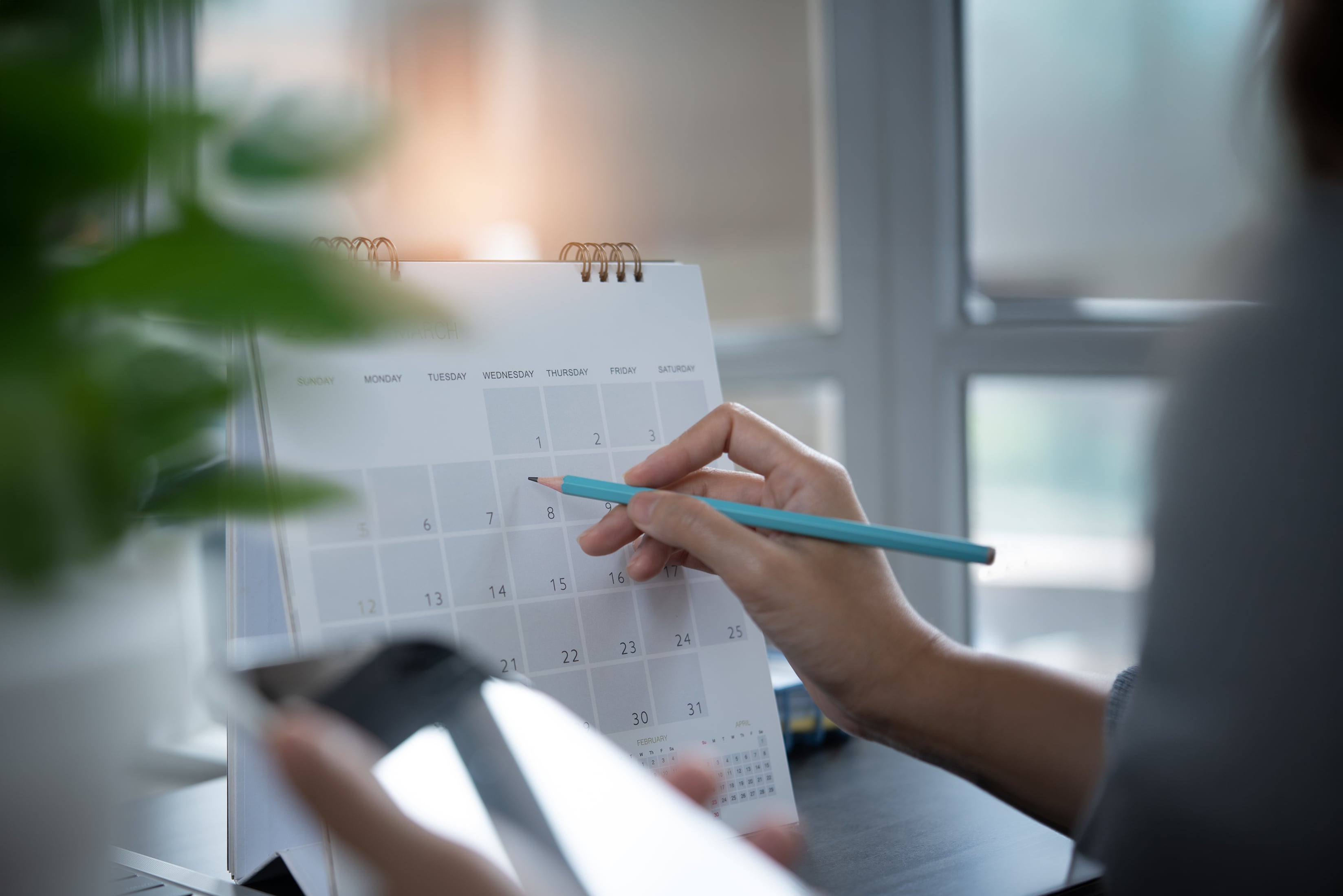 Person writing on calendar